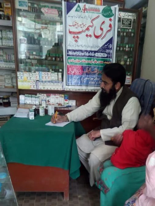 The doctor writing a prescription at the free homeopathic camp