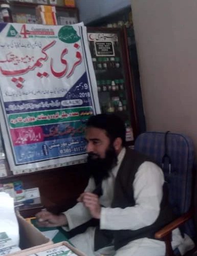 The doctor seated at the consultation desk during the free camp