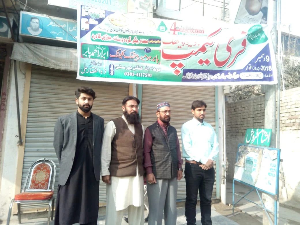 The clinic team standing under the banner of the free homeopathic camp, 9 December 2018
